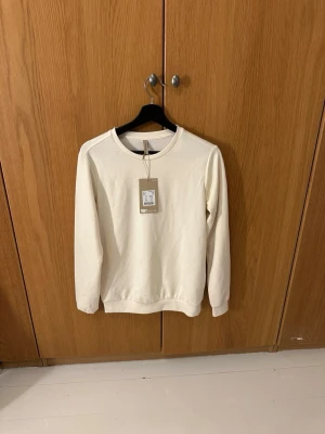 Vit/beige fin tröja från Soyaconcept - Jättefin vit sweatshirt från Soyaconcept i storlek XS. Säljes för de var fel storlek för mig. Testad en gång. Nypris ligger på ca450kr. 