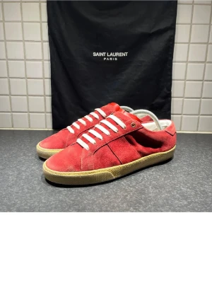 Saint Laurent röda mocka sneakers - Tja allihopa Säljer dessa tvär feta Saint Laurent i färgen röd som otroligt snygga nu till vintern! Skorna är i storlek 41 men kan även passa 42 utan den stjocka sulan! Skorna är i mycket bra skick dustbag medföljs. Nypris cirka 6-7000! Jag är altid intresserad av byten om du bor i Stockholm så vid minsta lilla fundering hör av dig till mig!