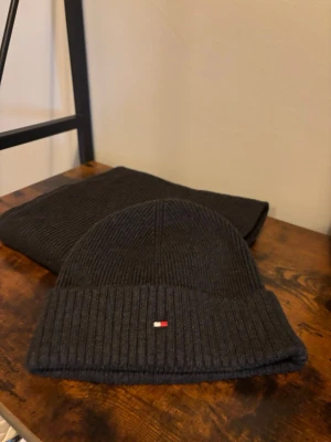  Tommy Hilfiger mössa – grafitgrå, One Size (oanvänd) - Stilren ribbstickad mössa från Tommy Hilfiger i färgen grafitgrå. Tidlös design med diskret flagglogga framtill. Mössan är oanvänd och i nyskick. One Size (OS) – passar de flesta. Passar perfekt till både vardag och mer uppklädda outfits.