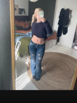 Nya LTB bootcut jeans - Säljer ett par blå bootcut jeans från LTB med snygga slitningar och hål på benen. Jeansen har låg midja och klassiska bakfickor med dekorativ söm. Dom är helt nya och oanvända, säljer då dom inte passar mig. Storlek 27/30 (27 i midja och 30 i längd) Köpt för 310 på rea!