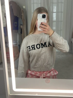 Grå/beige sweatshirt med text ”Amore” - En superfin grå/beige hyfsad tunn tröja med text, på texten står det ”Amore”. Jättefin vardagströja som passar alla tillfällen 💓💓💓💓Knappt använd!!