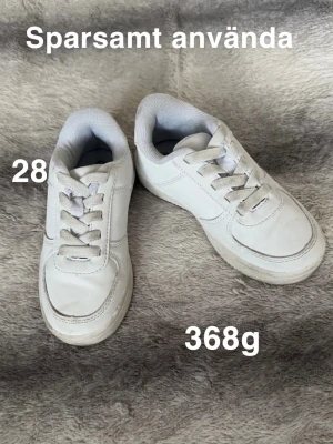 Vita sneakers med snörning, strl 28 - Klassiska vita sneakers i storlek 28 med snörning och rund tå. Skorna har en enkel och stilren design med vit sula. Perfekta till vardags för en clean look.🌸 Sparsamt använda. Lite smuts. Storlek 28