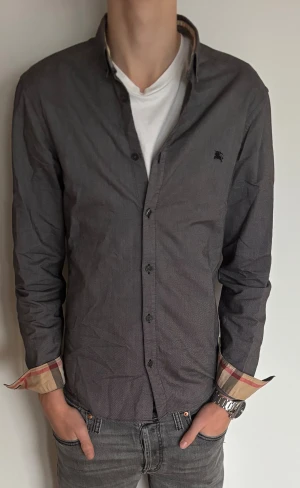 Mörkgrå Burberry skjorta  - En riktigt schysst burberry skjorta! Skjortan är i stl S och sitter perfekt! Modellen är 184 och har den perfekta passformen. Skick | 8/10 | den har ingen defekt! Pris 699kr och Nypris 4900kr så passa på!( priset är inte hugget i sten)