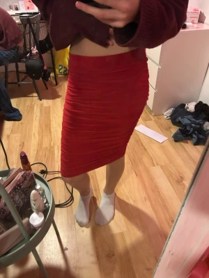 Röd tight kjol från NLY One - Säljer en röd tight kjol från NLY One i storlek S. Kjolen är figurnära och har snygga rynkade detaljer längs sidorna som ger en cool look. Perfekt att styla med en croppad topp eller stickad tröja. 70kr +frakt
