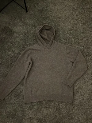 Merinoull stickad hoodie  - Stickad hoodie i merinoull. Extremt bra passform och väldigt varm hoodie. Storlek L men passar S/M. Mycket tjockare jämfört med andra merinoull hoodies, detta gör att den sitter mycket bättre och ser mer högkvalitativ ut 