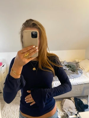 Mörkblå långärmad topp Gina Tricot - Snygg mörkblå långärmad topp från Gina Tricot i storlek S. Modellen är figurnära med långa ärmar och lätt utsvängda muddar. Mjuk och stretchig bomullskvalitet som är skön mot huden. Perfekt att matcha med jeans eller kjol för en cool look.