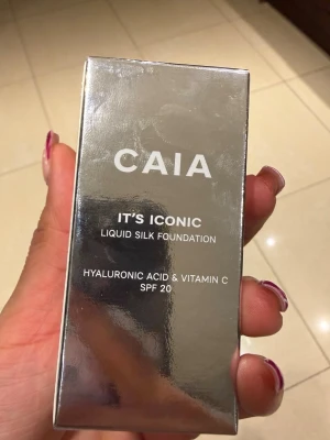 CAIA It's Iconic Liquid Silk Foundation 4W - Säljer en CAIA It's Iconic Liquid Silk Foundation i nyansen 4W. Foundationen kommer i en snygg silvrig förpackning och innehåller hyaluronsyra och vitamin C samt har SPF 20. Konsistensen är flytande och ger en silkeslen finish.