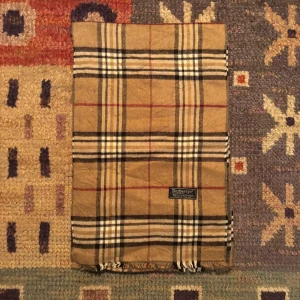 Vintage Burberry Halsduk - -Riktigt bra skick. Nypris på dessa ligger på runt 5000kr, vilket gör detta till ett sjukt bra pris! Halsduken är gjord i Lamull, och är perfekt inför hösten och den kommande vintern. Anledningen till att det står ”Burberry’s” och inte ”Burberry” på lappen är eftersom halsduken är från några år tillbaka, innan de bytte namn! Om du har någon fråga är det bara att skriva till mig. /elgnce (5)