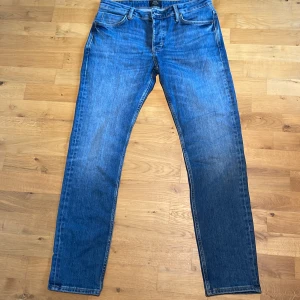 Blå jeans från Neuw Stockholm  - Säljer ett par klassiska blå jeans från Neuw Stockholm. Jeansen har en rak passform med fem fickor och snygga kontrastsömmar. Tillverkade i slitstarkt denim med en medelblå tvätt. Perfekta för dig som gillar en tidlös och clean look. Storlek 32:32. Aldrig använda. Skick 10/10