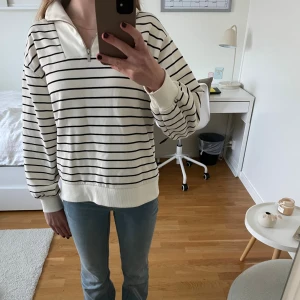 Randig half zip-tröja från Zara - Vit och svart randig tröja från Zara med half zip och krage. Tröjan har långa ärmar, breda muddar och en avslappnad passform. Perfekt för lager-på-lager och chill vardagsstil. Såå fin och säljer på grund av att jag har vuxit ur den!