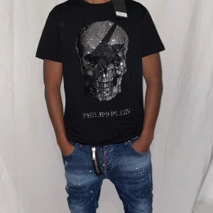 Philipp plein t shirt strl L  svart - Helt ny. Fin replika med grym kvalitét. Modellen är 175cm bär strl L. Normal i passformen. Pris : 899krFörst till kvarn som gäller. Skickas direkt inom 24h