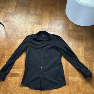 Svart slim skjorta från Hugo Boss - Stilren svart skjorta från Hugo Boss i slim fit-modell. 