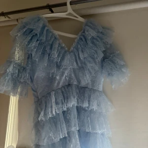 Ljusblå spetsklänning från By Malina - Superfin ljusblå långklänning från By Malina med flera lager volanger och spetsdetaljer.  Bara använd en gång.