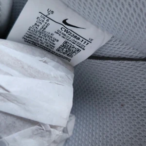 Nike Air Force 1 helvita sneakers - Fräscha helvita Nike Air Force 1 sneakers i klassisk low-modell. Skorna har snygg skinnöverdel, perforerad tå och ikonisk Nike Swoosh på sidorna. Platt sula och snörning framtill. Perfekta för dig som vill ha en clean och tidlös look.