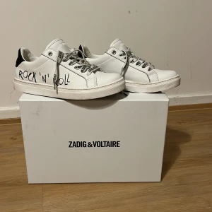 Zadig&Voltaire sneakers!  - Hejjj! Jag säljer mina fett snygga Zadig&Voltaire skor eftersom de är för små! Skorna är helt nya, och har haft på mig de 1 gång, men de har en liten  repa på en av sneakersens tår,  som ni kan se på andra bilden! De är vita och har snören med texten ”Zadig&Voltaire” och har en svart text på sidan om, skorna kommer med boxen, kan skicka mer bilder och PRIS KAN DISKUTERAS❤️💕NY PRIS: 2135kr