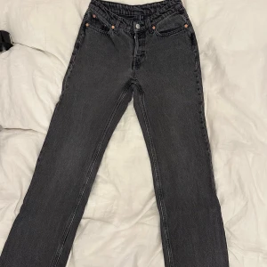 Weekday pin jeans gråa - Snygga svarta/gråa jeans från Weekday med raka ben och klassisk femficksdesign. Mid midja och knappgylf. Jeansen har en mörk tvätt och är tillverkade i ett robust denimtyg som ger en tidlös look. W26 L32