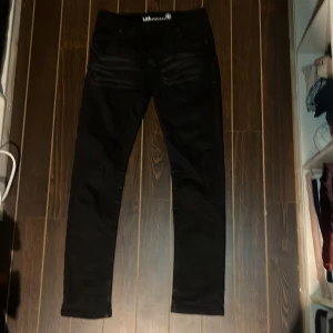 Svarta jeans från LAB Industries - Svarta jeans från LAB Industries med klassisk femficksdesign och diskreta slitningar framtill. Jeansen har normal passform och är tillverkade i ett mjukt och stretchigt material för extra komfort. Perfekta för dig som gillar stilrena och enkla byxor.