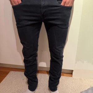 Replay Anbass mörkblå jeans, stl 33 - Snygga mörkblå Replay Anbass jeans i slim fit med klassisk femficksdesign och raka ben. Jeansen har en modern look med smal passform och är tillverkade i mjukt jeansmaterial som sitter skönt hela dagen.