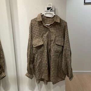 Brun/svart rutig oversized skjorta   - Oversized brun-rutig skjorta och två stora bröstfickor. Köpte denna utomlands, det står ingen storlek på, men den är ganska stor i storleken - Oversize. Väldigt snyggt med jeans! 🤎