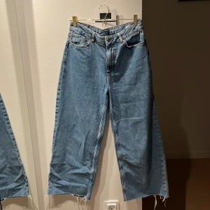 Blå Baggy jeans | Never Denim - Baggy ljusblå jeans med låg midja och fransiga benslut. Klassisk femficksmodell i 100% bomull med breda ben och avslappnad passform.   Köpte dessa begagnat och de var stora för mig i midjan - därför säljer jag de nu :) 💙