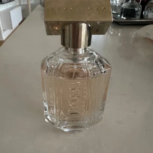 Hugo Boss The Scent parfym - Stilren parfym från Hugo Boss med elegant design. Flaskan har märkningen 'The Scent'. Perfekt för dig som vill ha en klassisk och modern touch i din samling.