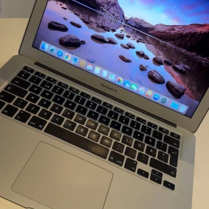 MacBook Air - Snygg MacBook Air med 1,6 GHz Intel Core i5, 4 GB RAM och Intel HD Graphics 6000. Kör OS X Yosemite. Aluminiumchassi i gott skick, inga synliga repor eller skador på skärm. Finns några stötmärken på nedre högra kant se bild 3. Perfekt för studier, surf och vardagsbruk ( enklare uppgifter). Levereras med svensk tangentbordslayout och laddare! Batteri behöver bytas men fungerar ändå ett bra tag utan problem