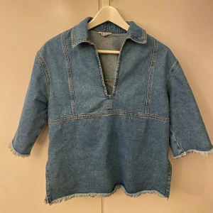 Blå denim skjorta - Säljer just nu denna sprillans nya denim skjorta från Object i storlek XS. Skjortan har en v-ringad öppning, trekvartsärmar med fransar och en loose passform. Perfekt för dig som gillar avslappnad och trendig stil!!🙌🏼🤩          (Org. pris 800kr.)