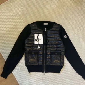 Moncler Cardigan Dam - Moncler tricot cardigan dam med quiltad framsida och snygga horisontella sömmar. Västen har en praktisk ficka framtill, dragkedja och Moncler-logga på ärmen. Materialet är polyester och dun, vilket gör den både lätt och varm. Perfekt för att addera en exklusiv touch till din outfit. Priset kan diskuteras! JAG LÄMNAR SAMMA DAG!!