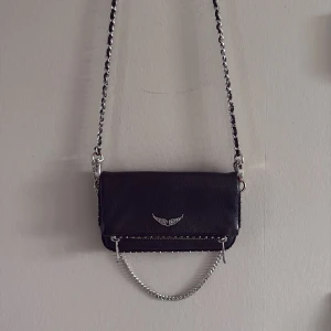 Zadig & Voltaire väska - Nyskick, enda defekten ser ni på sista bilden och då har en del av spännet gått av. Bredd: 24cm, höjd: 11cm. Nypris: 2650kr. Pris kan diskuteras!