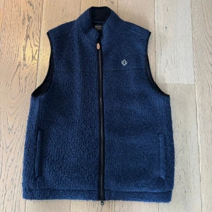 Morris fleeceväst - Snygg mörkblå fleeceväst. Väldigt sparsamt använd. Inköptes förra november. Blev lite för kallt för att använda då. Använd enstaka tillfällen. Har egentligen bara hängt i garderoben. Nypris 1999kr och är slutsåld överallt