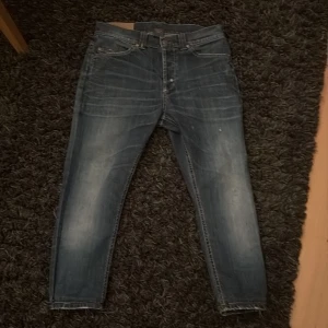 Blå donup jeans, storlek 31 - Snygga blå jeans från dondup i storlek 31. Jeansen har en tvättad look med slitningar på bakfickorna och klassiska fem fickor. Smal passform och raka, passarr dig som är runt 160cm. Kom gärna med bud!