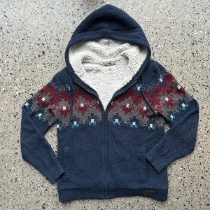 Stickad Hollister hoodie - En stickad Hollister zip-hoodie med snyggt mönster. Tröjan har även otroligt skön fodring! 