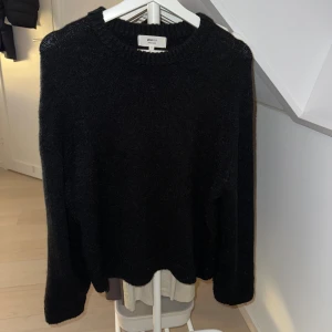 Svart stickad tröja Gina Tricot XS - Mysig svart stickad tröja från Gina Tricot i ullblandning. Tröjan har rund hals och långa ärmar, perfekt för kyliga dagar. Enkel och stilren design som är lätt att matcha med olika outfits.