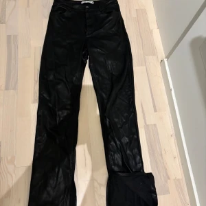 Svarta skinnbyxor från Zara, strl 36 - Snygga svarta skinnbyxor från Zara i storlek 36. Byxorna har klassisk femficksdesign, bälteshällor och raka ben. 
