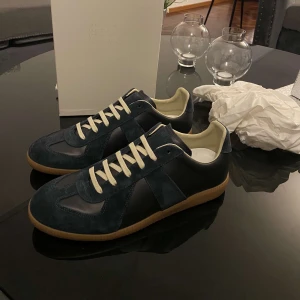 Mörkblå sneakers från Maison Margiela - Maison Margiela sneakers i mörkblå mocka och skinn Snygg och stilren design som passar till jeans och streetwear. Kvitto finns!