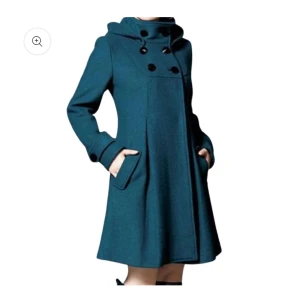 Blå kappa med huva och knappar - Snygg turkos kappa med avtagbar huva och dekorativa svarta knappar framtill. Jackans material är en ullblandning och den har fickor på sidorna samt knappdetaljer på både ryggen och ärmarna. Endast provad en gång då den var för liten för mig. Storlek M men troligen närmare S. Husdjur finns i hemmet. 