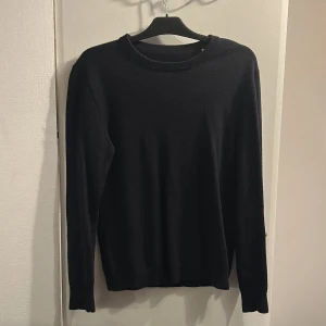 Svart stickad tröja med rund hals - En enkel svart stickad tröja i merinoull.              Från märket ”these glory days” och är köpt från Volt. Den är storlek M och är lite för tajt för mig som är 186 cm och väger ungefär 75 kg
