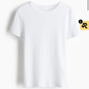 Vit ribbad t-shirt med kort ärm - En stilren vit t-shirt med ribbad struktur och rund hals. Modellen har korta ärmar och är gjord i mjuk bomull som känns skön mot huden. Perfekt för dig som gillar enkla och cleana plagg med en liten twist i materialet.