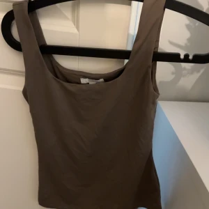 Brun topp - Oanvänd, normal i storleken.