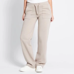 Beiga mjukisbyxor med snörning - Snygga beiga mjukisbyxor med bred resår i midjan och snörning framtill. Byxorna har raka ben, stora fickor fram och bak samt är tillverkade i mjukt bomullsmaterial. Perfekta för en chill och avslappnad look.