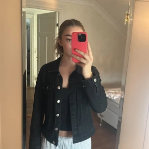 Svart jeansjacka från Zara - Svart jeansjacka från Zara med klassisk krage och silverfärgade knappar framtill. Jackan har två bröstfickor med lock och långa ärmar. Skit snygg jeans jacka som är lite tunnare, den är jätte fin på och väldigt bra nu till hösten/vintern ☺️den är från Zara ‼️