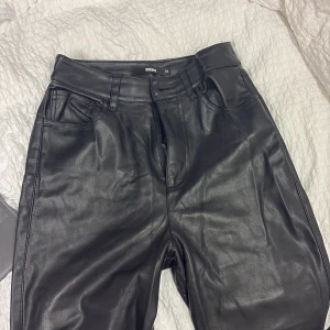 Svarta raka skinnbyxor från Bik Bok - Svarta byxor i skinnimitation från Bik bok 