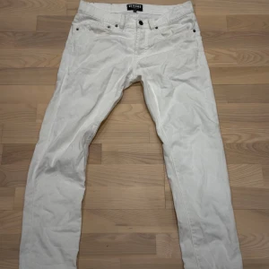 Vita jeans från Versus Versace - Snygga vita jeans från Versus Versace med klassisk femficksdesign och svart patch med lejonlogga bak. Byxorna har raka ben och är tillverkade i bomullstyg. Perfekta för dig som vill sticka ut med en clean och exklusiv look.