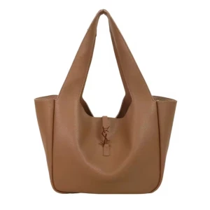 Beige axelväska från Yves Saint Laurent - Snygg beige axelväska från Yves Saint Laurent med guldigt YSL-emblem framtill. Väskan har en stilren och rymlig design med breda axelremmar och är tillverkad i slätt skinn. Perfekt för dig som vill ha en klassisk och trendig väska med lyxig känsla.