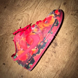 Nike SB Dunk Low x Wizard of Oz 42,5 - Unika Nike SB Dunk Low sneakers i samarbete med Wizard of Oz. Skorna har ett färgstarkt, blommigt mönster i rött, orange och svart med röda snören och satinliknande foder.  Og box och tillbehör medföljer.  Storlek EU 42,5