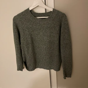 Grön stickad tröja med rund hals - En enkel och stilren grön stickad tröja med rund hals och långa ärmar. Perfekt för dig som gillar en klassisk look och vill ha något som är både bekvämt och snyggt. Passar till jeans eller chinos och är lätt att matcha med andra plagg.