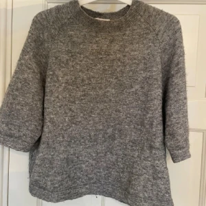 Grå stickad tröja & Other Stories XS - Mysig grå stickad tröja från & Other Stories, Stockholm Atelier. Tröjan har rund hals, trekvartsärm och en loose passform som ger en chill vibe