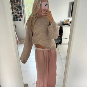 Ljusrosa långkjol med slits - Säljer en ljusrosa långkjol med snygg slits framtill. Kjolen har en flowy och luftig passform med resår i midjan för extra komfort. Materialet är tunt och känns skönt mot huden, perfekt för varmare dagar. Enkel och stilren design som är lätt att matcha.