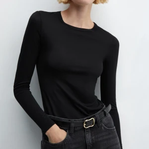 Enkel långärmad tröja - Helt oanvänd. En klassisk och enkel svart långärmad topp från Mango med rund halsringning och figurnära passform. Tillverkad i mjuk och stretchig bomull som sitter skönt mot kroppen. Ordinarie pris 199kr.