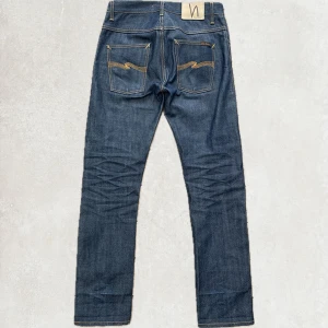 Nudie Jeans Raw Selvedge  - Nudie Jeans Raw Selvedge Selvage Denim  Storlek 29/32, model hank-ray sitter straight, knappt använda men börjar få lite fades, jeansen är i ny skick och har inga defekter, köpta för 2500, mitt pris endast 1099.   Mått +/- 1cm  Totallängd: 107cm Benöppning: 18.5cm Midja: 39.5cm Inseam: 79cm  Pris är diskuterbart vid snabb affär.